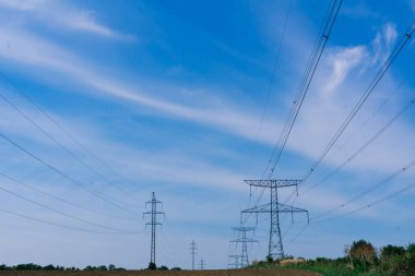 Gökyüzü arka planında elektrik iletim hatları, bir sonbahar alanı