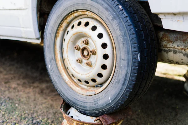 Bratislava, Slovakya - 05.09.2021. Eski paslı araba tekerleği. Çatlak lastikler ve paslı jant kapakları..