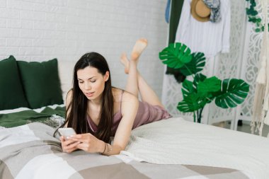 Akıllı telefon tutan kadın eli görüntüsü. Evde cep telefonu olan bir kadın. Seçici odak