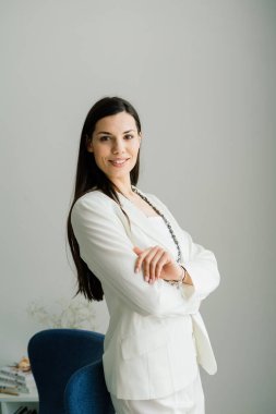 Masada oturan genç bir kız öğrenci, çalışırken akıllı telefon kullanıyor..