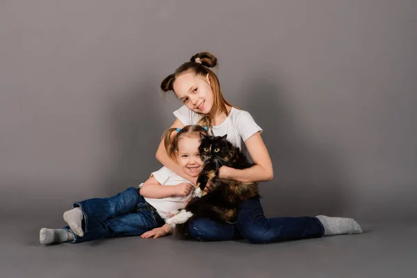 Twee Meisjes Zussen Knuffelen Zwart Kat Een Studio — Stockfoto