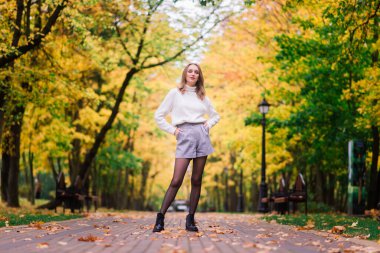 Güz ormanlarında gitar çalan güzel bir kadın.