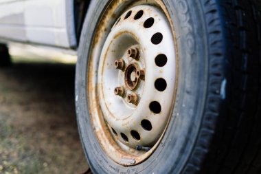 Bratislava, Slovakya - 05.09.2021. Eski paslı araba tekerleği. Çatlak lastikler ve paslı jant kapakları..