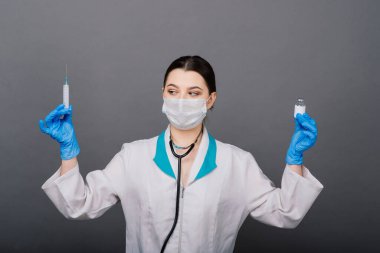 Şırıngalı bir bilim adamı klinik deneye hazır olması için bir araştırma aşısında virüsü analiz ediyor..
