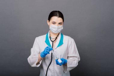 Şırıngalı bir bilim adamı klinik deneye hazır olması için bir araştırma aşısında virüsü analiz ediyor..