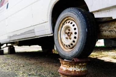 Bratislava, Slovakya - 05.09.2021. Eski paslı araba tekerleği. Çatlak lastikler ve paslı jant kapakları..