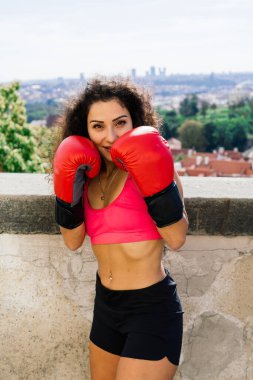 Kadın gücü, kendini savunma kavramı. Çekici ve formda bir boksörün portresi, dövüşmeye hazır.