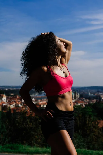 A woman boxer training outdoor - city and nature in a background