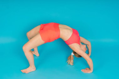 Sportif kız dambıllarla egzersiz yapıyor. Silüet stüdyosu koyu ve beyaz bir arka plan üzerinden çekiliyor.