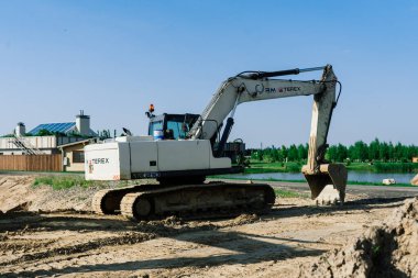 Excavator in quarry extracting stone, soil ground