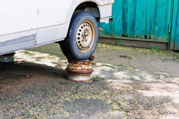 Old rusty car wheel. Cracked tires and a rusted hubcaps.
