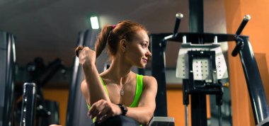 Beautiful muscular fit woman, she is exercising and building muscles