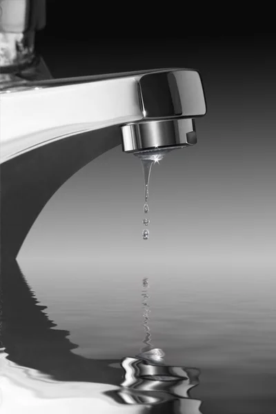 Dripping faucet over water surface — Stock Photo, Image