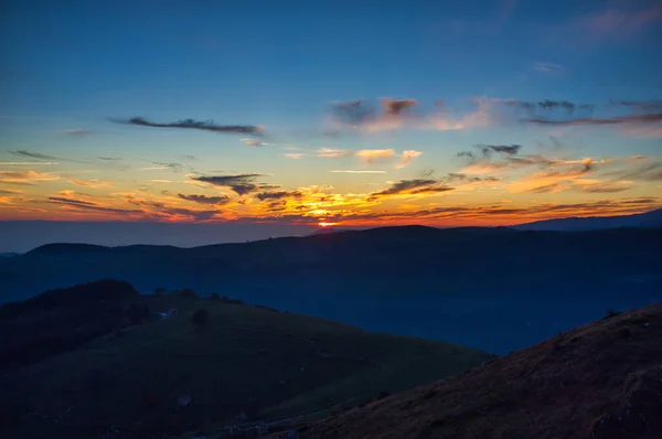 山の中の暗い 鮮やかな夕日 ロイヤリティフリーのストック写真