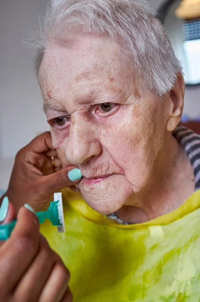 Anciana Recibiendo Depilación Facial Del Cuidador Afroamericano — Foto de Stock