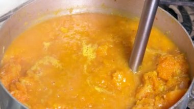 Making pumpkin soup with an immersion blender