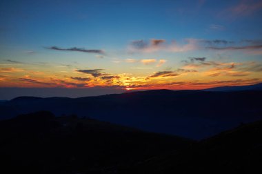 Dağlarda gün batımının manzarası ve altında kopya alanı