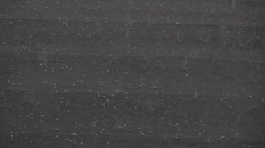 Slow motion of hail storm hitting roof during a bad weather summer storm