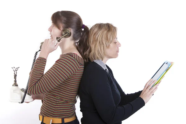 Duas mulheres de negócios, uma usando o telefone e outra um tablet — Fotografia de Stock