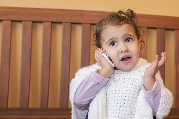 Holčička hovoří do telefonu doma. — Stock fotografie