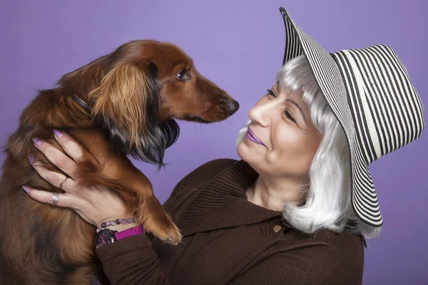 Женщина средних лет держит собаку — стоковое фото
