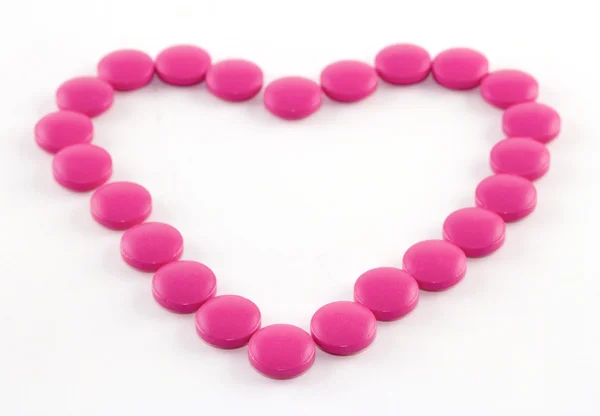 Pink tablets on a white paper — Stock Photo, Image