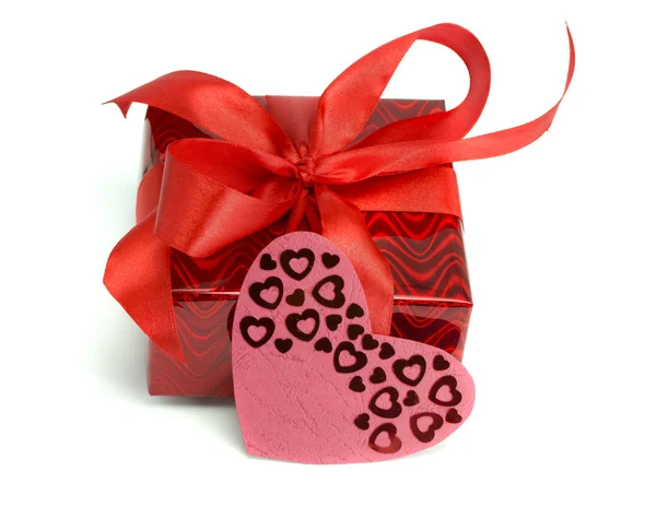 Red gift tied up by a bow and a card heart — Stock Photo, Image