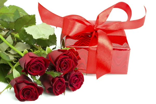 Bouquet di rose e regalo rosso legato da un fiocco — Foto Stock