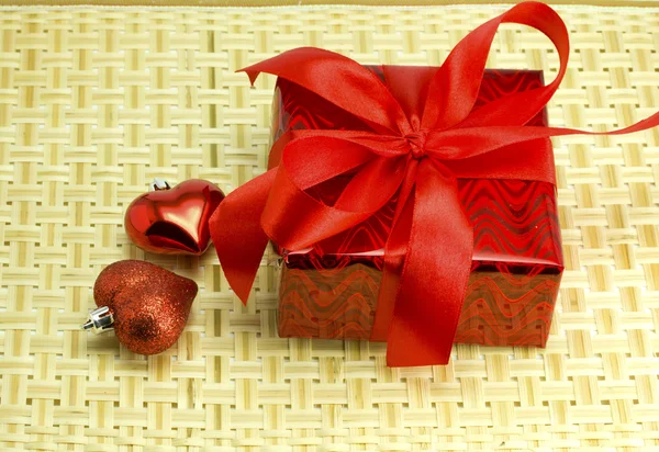 Gift and hearts on a wicker wood — Stock Photo, Image