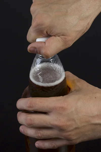 Ein Mann öffnet eine Flasche Bier — Stockfoto