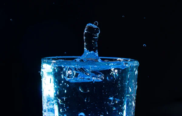 Una goccia in un bicchiere d'acqua sotto forma di pugno — Foto Stock