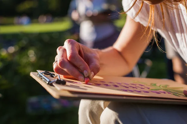 Girl draws flowers with pastels — Stock Photo, Image