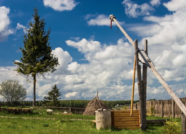 Rurale landschap met platteland werf, hek en oude houten draw goed — Stockfoto