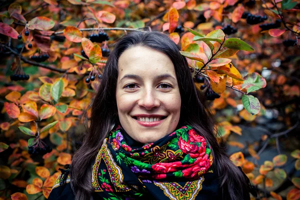 Flicka stående mot hösten färgade blad — Stockfoto