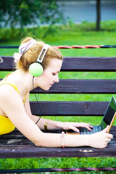 Mulher encantadora tendo descanso no parque com laptop — Fotografia de Stock