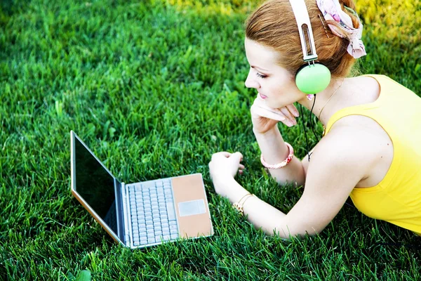 Jonge vrouw met rust in het park met laptop — Stockfoto