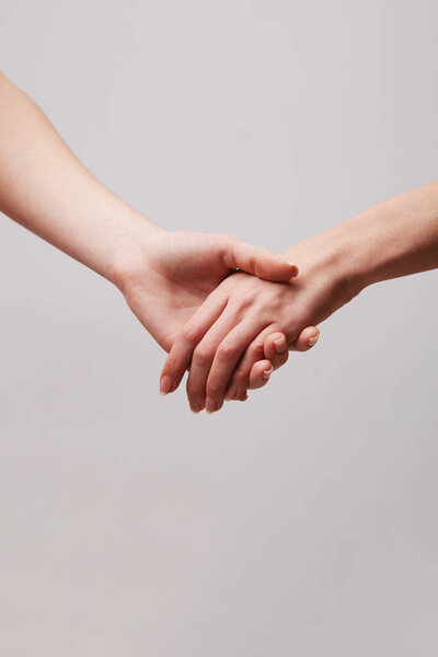 Two tender female hands are holding each other