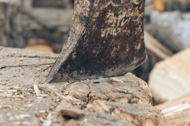 Güzel. Ahşap saplı eski bir balta yakacak odun yığınının üzerinde duruyor.