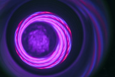 Tasarım için desenli bir arka plan deseni üzerinde mor ışık bulunan soyut girdap tüneli.