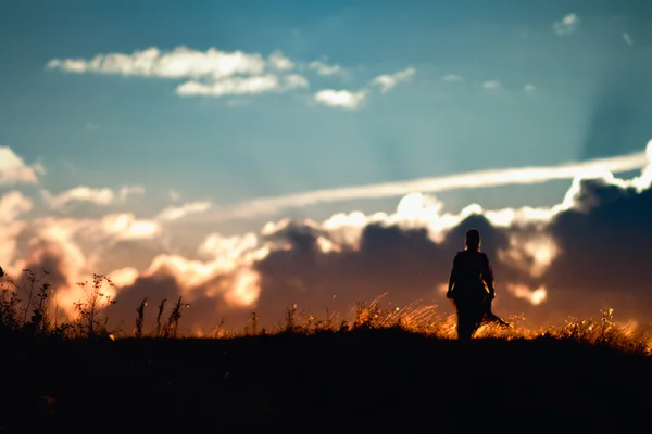 Silhouette of a girl walking in the sunset — Stock Photo, Image