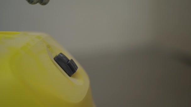 Hand van een onbekende bouwer in een bouwhandschoen zet een gele industriële stofzuiger aan. Bouw en renovatie, vastgoedconcept — Stockvideo