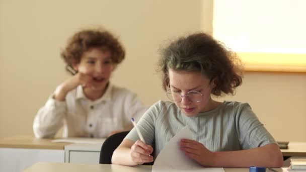 Zurück zur Schule. Schülerin betrügt beim Test in der Schule. Der strenge Lehrer geht rüber und nimmt die Hinweise auf. Konzept für Schulprüfungen — Stockvideo