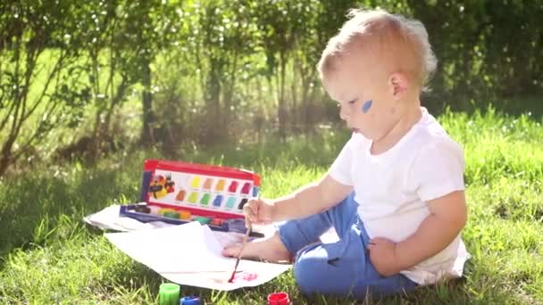 Maluch uczy się malować w przedszkolu. Zadowolony malarstwo małe dziecko z pędzlem w przyrodzie, brudne poważne skupione twarz, radość i kreatywność — Wideo stockowe
