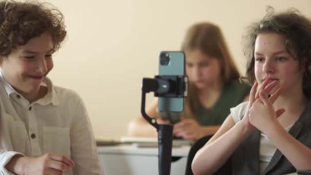 Linda chica de pelo rizado colegiala graba un video para las redes sociales utilizando un steadicam y un teléfono inteligente — Vídeos de Stock