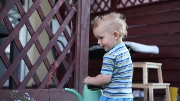 물갖고 노는 행복 한아이. 정원에서 꽃에 물을 주는 귀여운 금발의 아기. 여름 방학 — 비디오