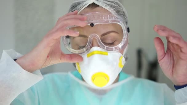 女医生在一次眼镜蛇-19大流行病中摘下眼镜和防护面罩，从面罩、红斑上可以看到面部痕迹。新的病毒株omicron — 图库视频影像