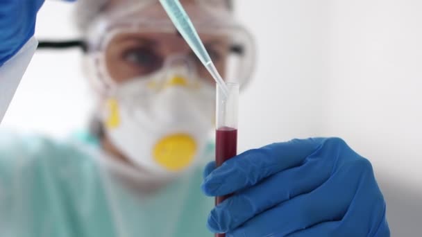 Close portrait of a microbiologist holding a test tube. Studies of a blood plasma sample, a new virus strain, Scientific research of the covid-19 vaccine — Stockvideo