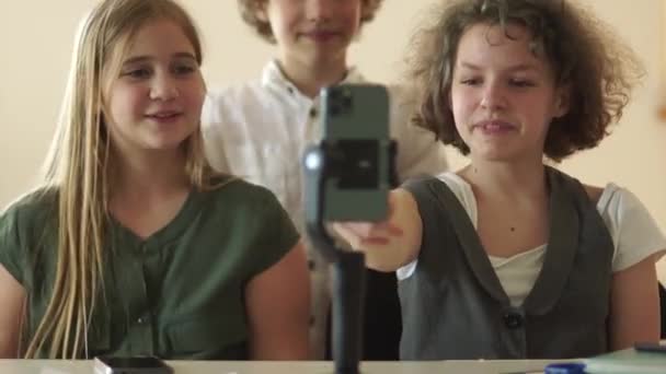 Trois camarades de classe drôles lycéens ayant des appels vidéo amusants, souriant et riant. Enfants et gadgets — Video