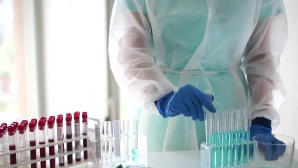 Registro de la muestra de sangre positiva de covid-19. Primer plano de un asistente de laboratorio registra los resultados de las pruebas de PCR en laboratorio médico durante la pandemia de sars-cov-2 — Vídeo de stock