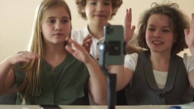 Sevimli liseli kızlar ve okul çocuğu akıllı telefon kamerasıyla video kaydediyor. Sosyal medya eğilimlerini yakalayan gençler, okuldaki gençleri etkileyen gençler. Video günlüğü ve hikaye kavramı